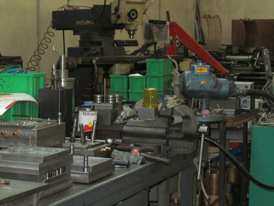 Operatore che controlla le misure di un componente plastico con un calibro